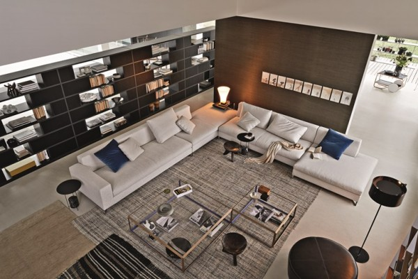 Phòng khách sáng với sofa góc L lớn màu xám nhạt và kệ sách tường