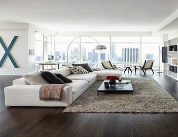 Phòng khách rộng phong cách châu Âu với sofa chữ L trắng và cửa kính lớn nhìn thành phố