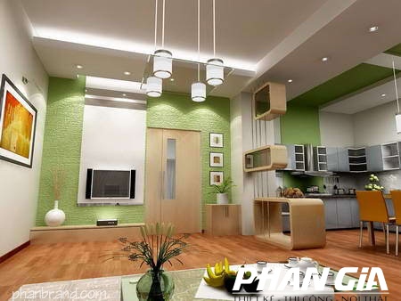 Phòng khách liên thông bếp với tường nhấn xanh lá và sàn gỗ ấm áp