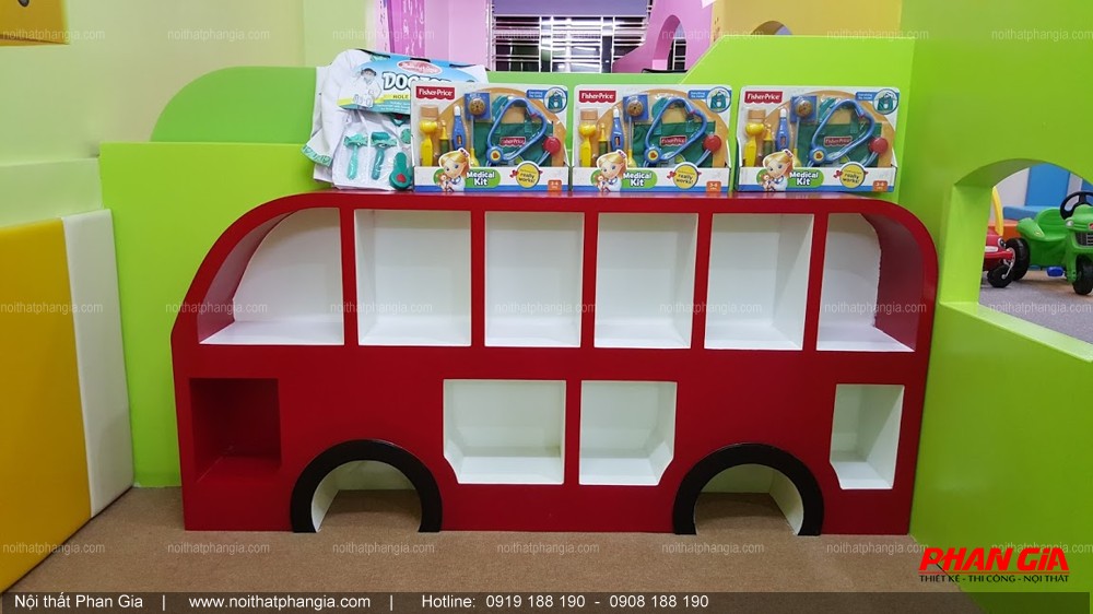 Kệ đựng đồ chơi hình xe buýt màu đỏ đặt trong khu vui chơi trẻ em